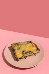 Piece of casserole with cheese and spinach.