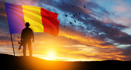 Silhouette of soldier with national flag on background of sunset. Romania National Day, the Great...