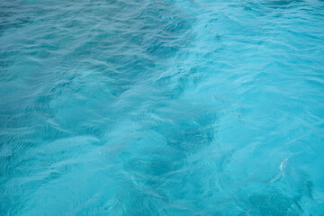 Fototapeta premium Abstract natural background, surface, texture. Waves of blue sea water. Copy space. Selective focus..