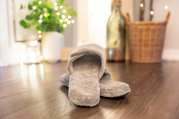 Women's comfortable slippers on a hardwood floor. Bright modern bedroom scene. 