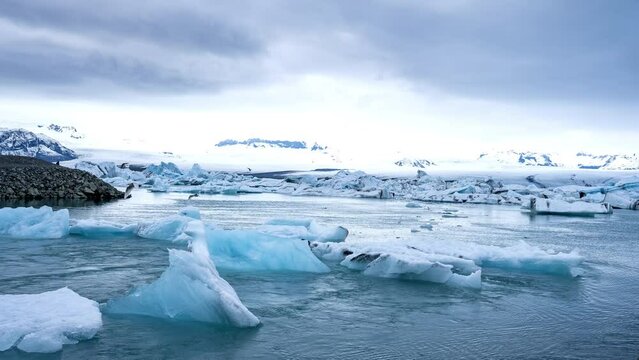 Tabular icebergs melt at turquoise ocean bay. Huge high ice glacier at polar nature environment. Arctic winter landscape at global warming problem. Desert white land of snow and ice timelapse.