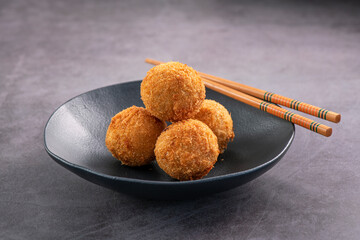 Deep fried salmon balls. Delicious appetizer served on dark dish. Studio soot on slate background.