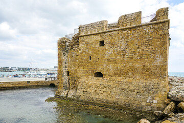 Paphos Castle and breakwater from large rocks on a Mediterranean background