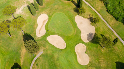 Aerial view of a golf course in the morning. There are no people on the putting green.