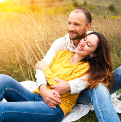 Happy couple of lovers smiling and hugging in nature at sunset. The concept of love and happiness.