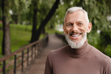 Closeup cropped portrait of a smiling with toothy smile confident caucasian handsome mature man...
