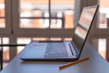 Laptop in a house with large windows prepared for teleworking.