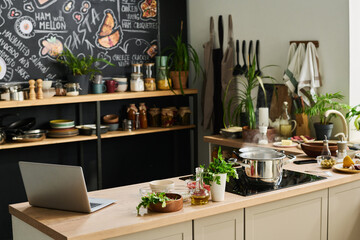 Horizontal no people shot of modern loft kitchen at home or studio interior design with laptop and ingredients on counter