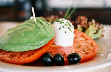 Avocado, tomato, lettuce and black olives salad in a restaurant in summertime