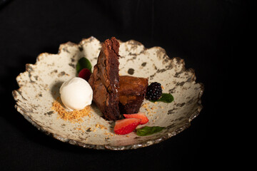 Chocolate brownie with strawberries and vanilla ice cream.