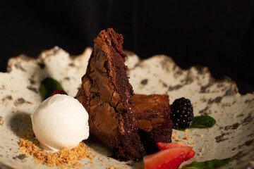 Chocolate brownie with strawberries and vanilla ice cream.