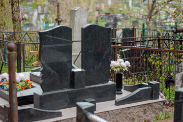 Series of monuments made of black gabbro-diabase granite on the graves of the deceased in a cemetery in Eastern Europe