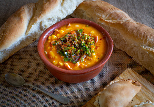 Locro en cazuela de barro con pan casero y empanadas