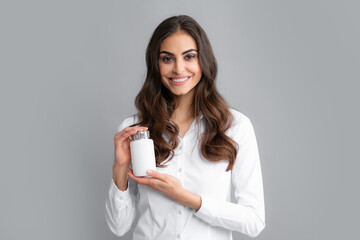 Woman with bottle pills. Happy young African American woman holding bottle of dietary supplements or vitamins in her hands. Healthy lifestyle concept.