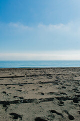 Horizontal lines of the beach, the sea and the calm sky, in vertical plane