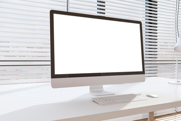 Blank white modern computer monitor with copyspace for your text on white table in sunny room with blinds on windows. 3D rendering