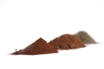 piles of paprika, nutmeg and dried fennel isolated on white background