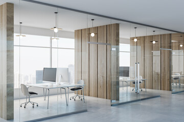 Side view on modern spacious coworking office with wooden wall partitions, modern computers on minimalistic style tables, concrete floor and glass wall instead windows. 3D rendering