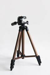 Modern compact tripod for camera on white with shadow