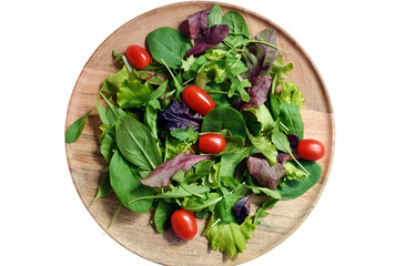 Fresh green salad with spinach, arugula, romaine and lettuce, decorated with cherry tomatoes, on wooden plate, isolated on white , top view