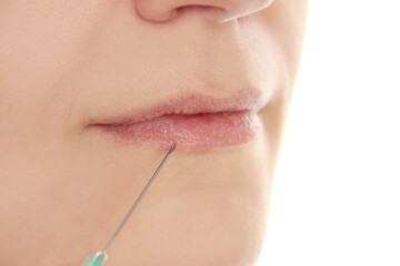 Obraz premium Woman receiving filler injection in lips, closeup