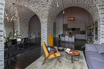 modern luxury design of a brutal apartment interior with arches in the style of a medieval castle with bright accents. free layout, kitchen area, seating and eating area.