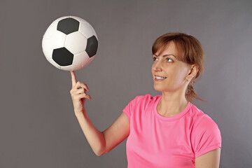 Young beautiful woman holding soccer ball over isolated background