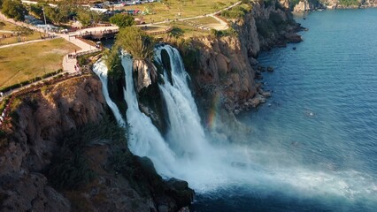 Top aerial view on a waterfall falling from a cliff