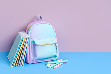 School backpack with stationery and notebooks in pastel color on pink background. Concept back to school. School supplies.