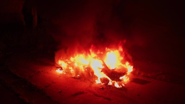 Car on fire. Accident. Spectacular night scene of burning old car explosion. Filming area. Horror thriller movie decoration. Aerial drone flight.