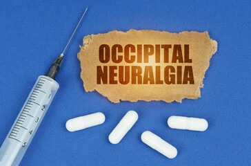 On a blue surface lie a syringe, pills and a cardboard sign with the inscription - Occipital...