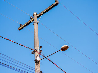 Street light lamp post in Brazil. Sunny day, clear skies. Lots of wires.