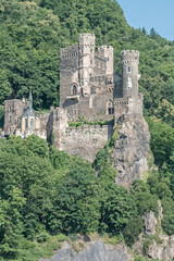 Obraz premium The 14th century Rheinstein Castle perched on a rocky promontory along the Rhine River in Germany.