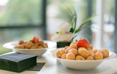 A bowl of delicious warm, sugar-coated mini donuts...and a strawberry