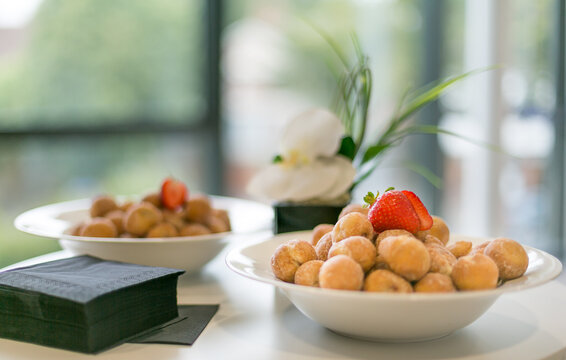 A Bowl Of Delicious Warm, Sugar-coated Mini Donuts...and A Strawberry