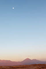 Sunset at the Moon Valley (Valle de la Luna) with the Licancabur volcano and the moon in the background, Atacama, Chile, South America