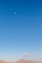 Sunset at the Moon Valley (Valle de la Luna) with the Licancabur volcano and the moon in the background, Atacama, Chile, South America