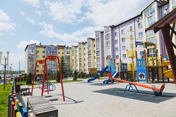 Fototapeta na wymiar New residential high-rise buildings. Apartments with balconies in a new area. Modern residential buildings. Children's playground in the courtyard of a residential building.