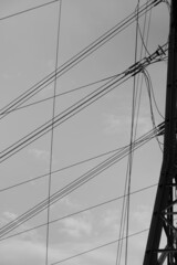 Fototapeta premium Elektrizität wird durch Kabel und Seile geleitet und transportiert, Hochspannung in einer Freileitung mit Mast