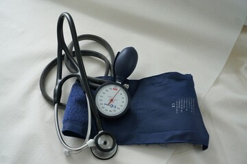 Blutdruckmessgerät auf weißem Stofflaken in Arztpraxis 