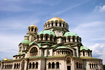 Fototapeta na wymiar Exterior of the Alexander Nevsky cathedral in the center of Sofia, capital city of Bulgaria, on a sunny day and blue sky for a tourist report - beautiful orthodox symbol for a travel around balkans