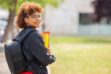 african american student girl with books and backpack on campus