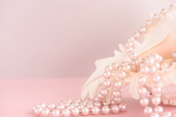 Beauty pearl beads at shell on pastel pink background