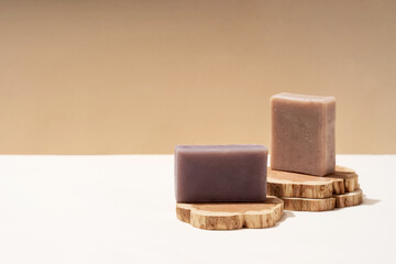 Beige wood podium, handmade soap, natural dry plant. Brown sun shadow background. Cosmetic pedestal for product promotion.
