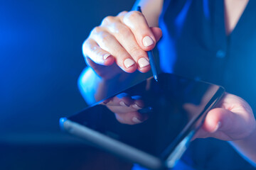 Woman uses a smartphone with a stylus. Close-up of a woman using her mobile phone. A girl with an electronic device. Female hands with smartphone. Electronic gadgets. A smartphone with a touchscreen