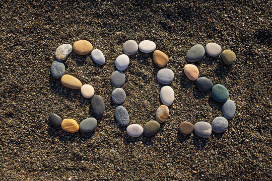 SOS message made with stones on the beach