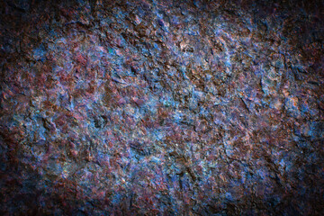 Multicolored granite texture with dark vignette. Stone background with copy space for design.