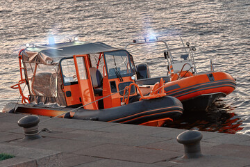 Orange rescue boats on the pier. Water police transport.