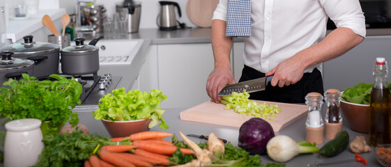 Man preparing vegetarian food meal cutting cellery on cutting board. Homemade meal