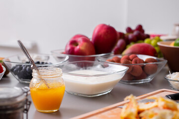 Yogurt in glass bowl with healthy breakfast on table.